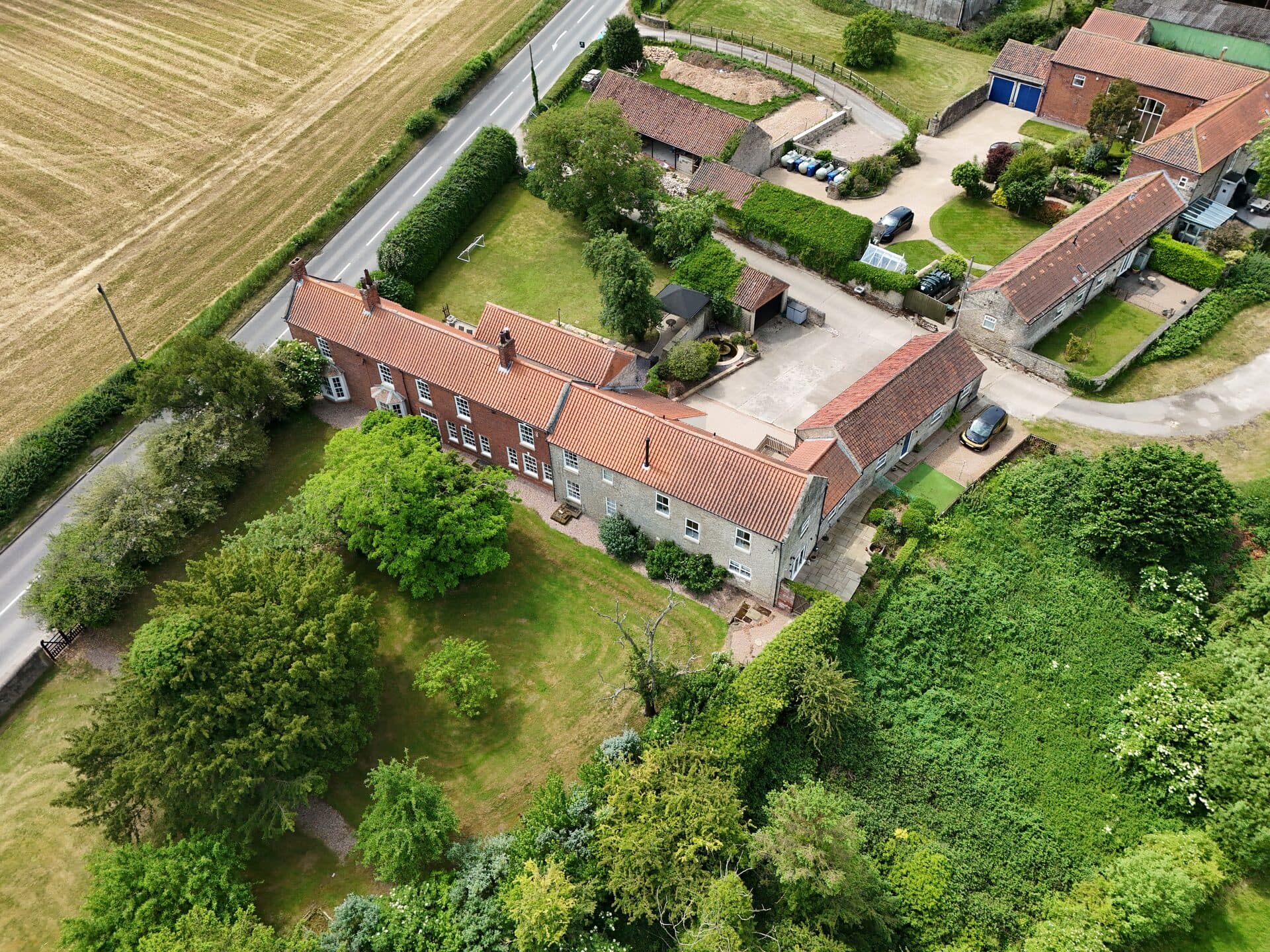 Aerial view of homes and gardens set among mature trees in a South Yorkshire village
