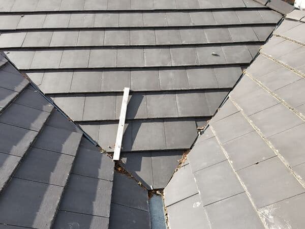 Close roof detail photo showing tiled roof valleys, ridge lines and areas where debris can collect.