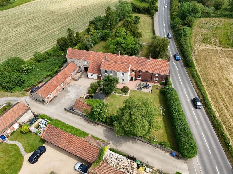 Aerial property photo showing the full plot, driveway, road access and surrounding farmland.