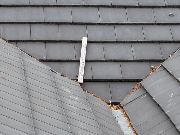 Close aerial view of a tiled roof valley between two pitches, where debris tends to collect.